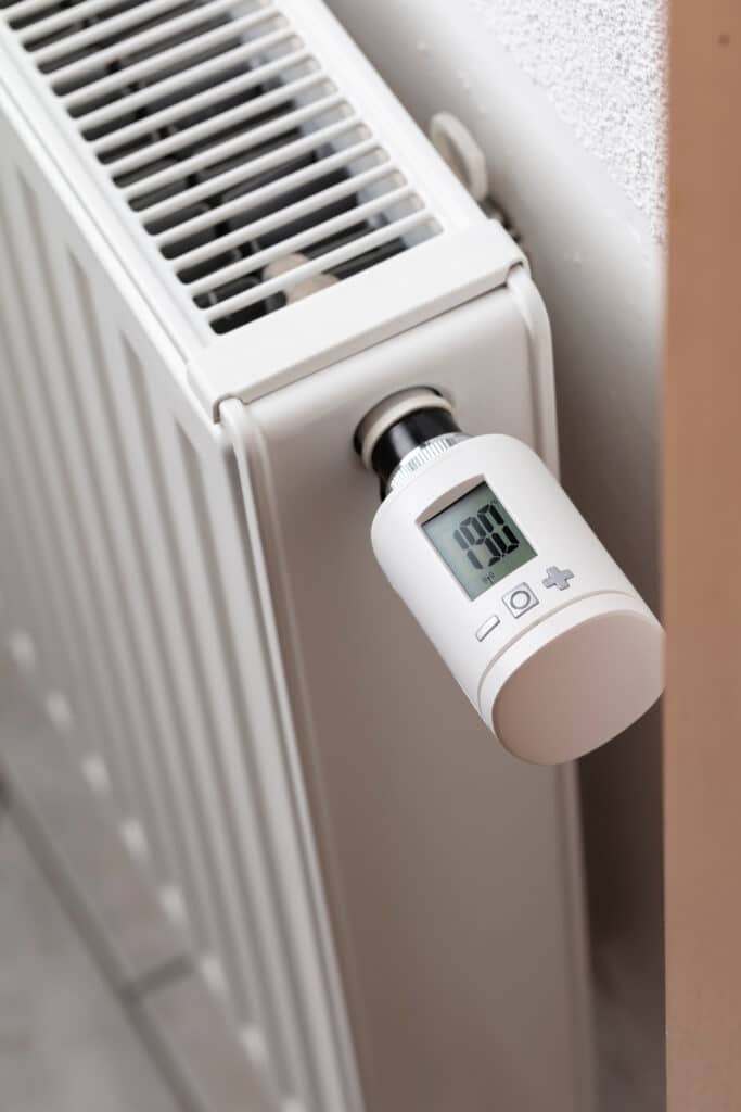 Radiateur blanc moderne équipé d'une vanne thermostatique digitale affichant 19.0°C. Optimisation du chauffage.